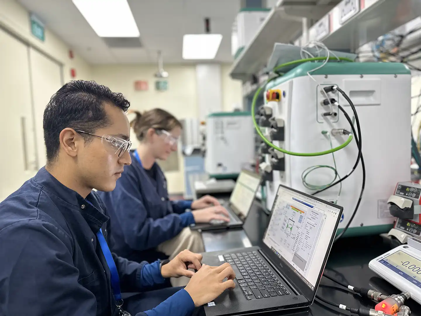 Global Service team members performing aftermarket services on an AES bioprocess controller, specifically a Site Acceptance Test (SAT)